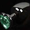 Графитовая анальная пробка с зеленым кристаллом в виде сердечка - 6 см.